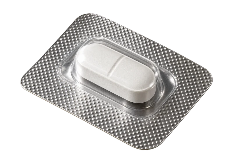 A single white tablet in a silver foil blister.